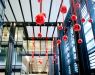 Extension of outside decorations are red Christmas ornaments hanging under the ceiling 