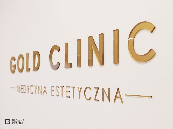 Główka Pracuje - Realizacja dla firmy Gold Clinic - logotyp z plexi bezbarwnej podklejonej złotą folią