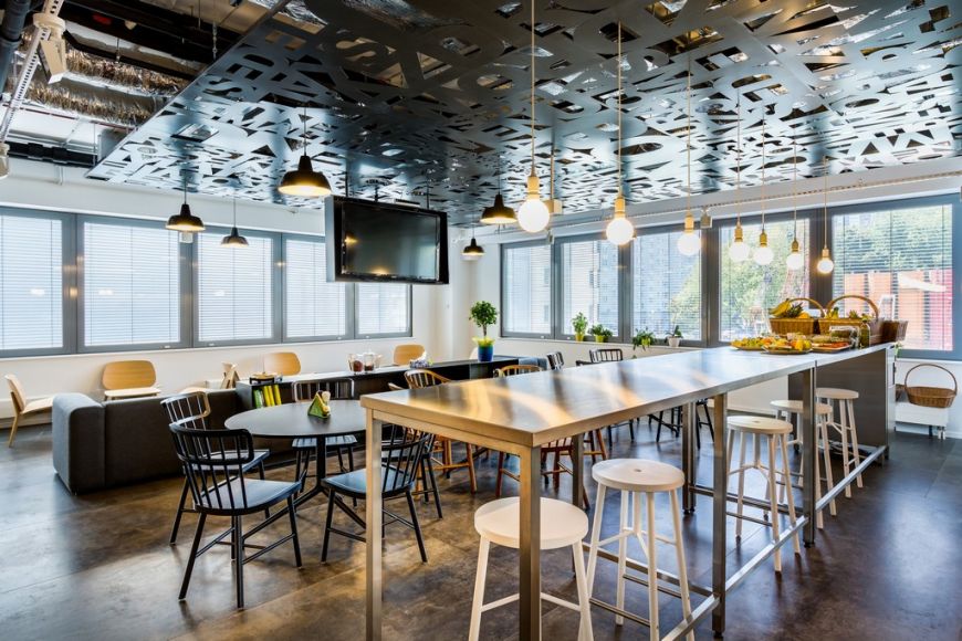  - Users of the office start their day with eating breakfast together in a modern kitchen