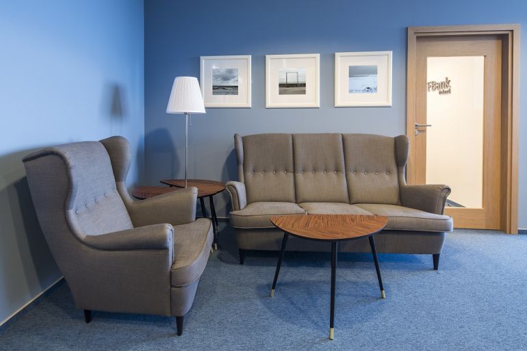 There are blue walls with wooden elements in the office